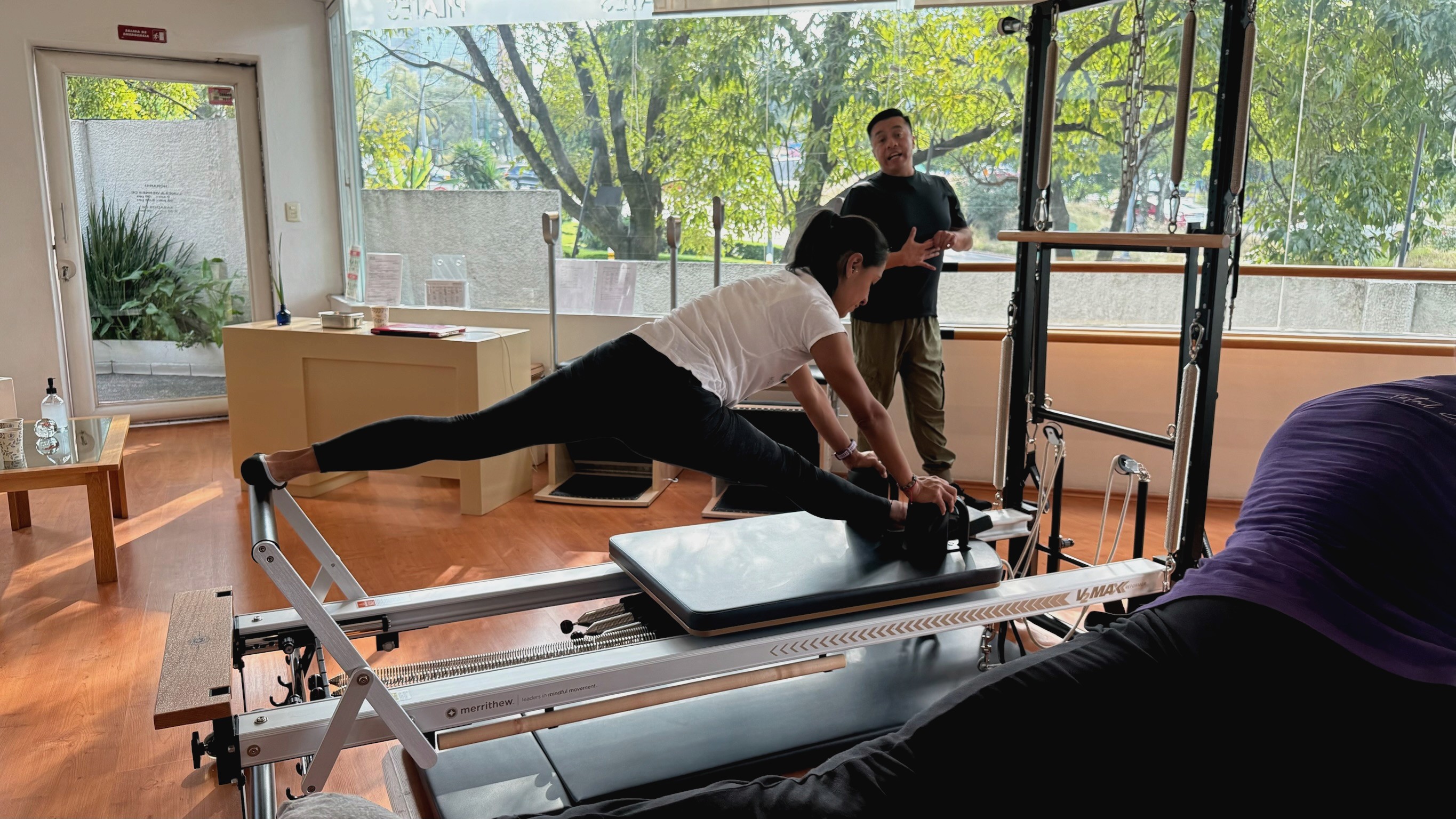 a woman is doing a yoga pose in front of a window